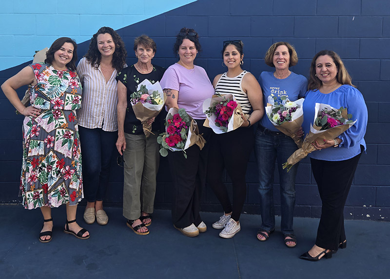 7 Women Standing in front of a wall