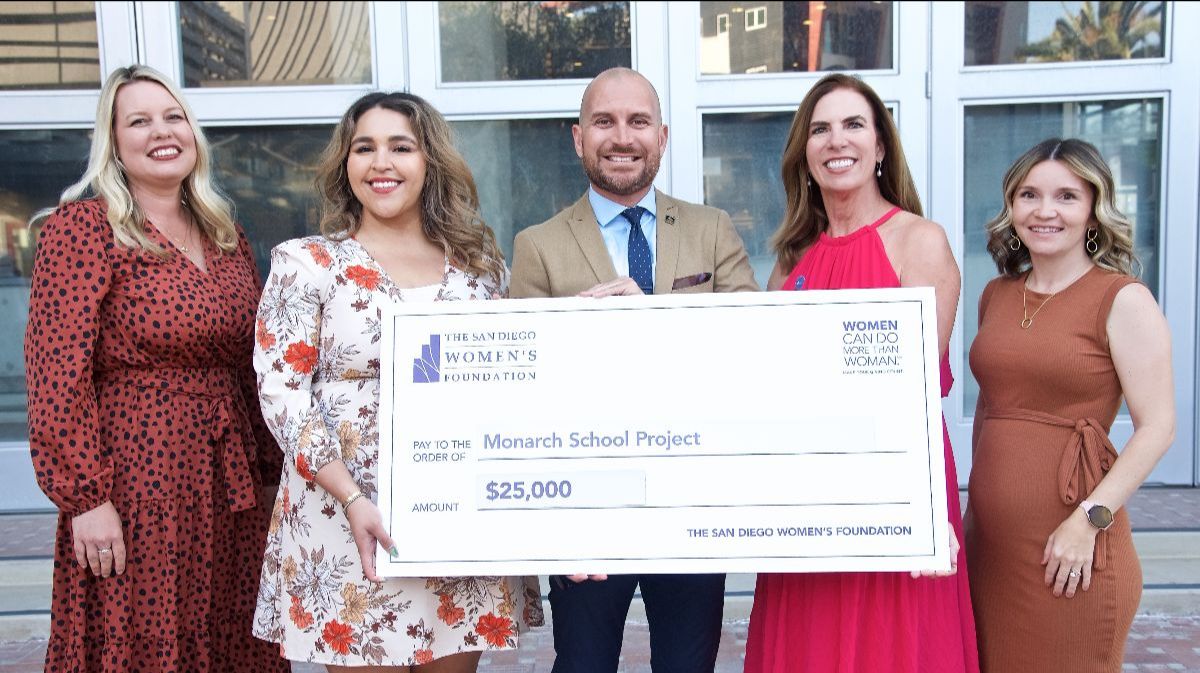 5 Professional People holding a big check